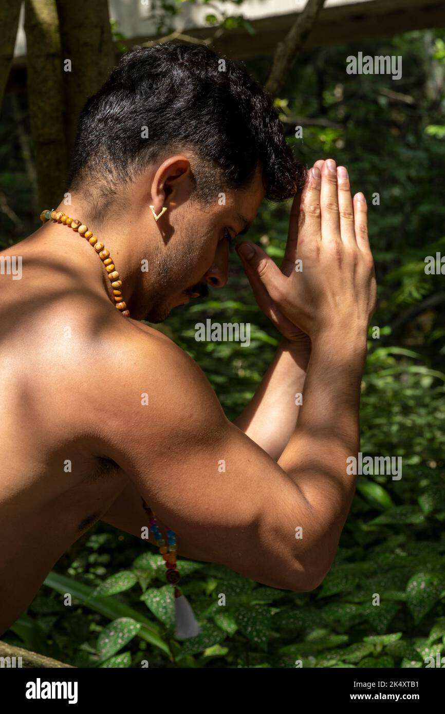 young man, doing yoga or reiki, in the forest very green vegetation, in mexico, guadalajara, bosque colomos, hispanic, Stock Photo