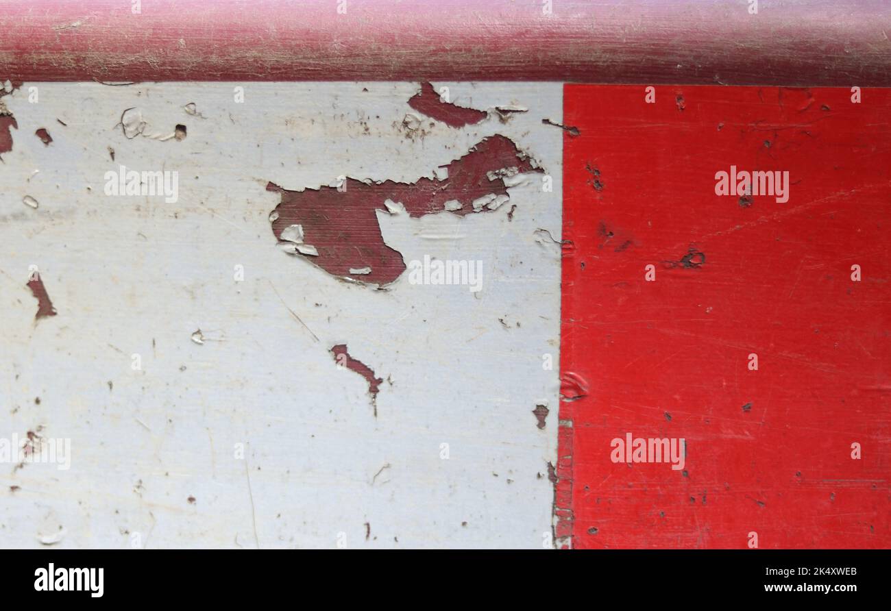 Background showing peeling red and white paint on road sign Stock Photo