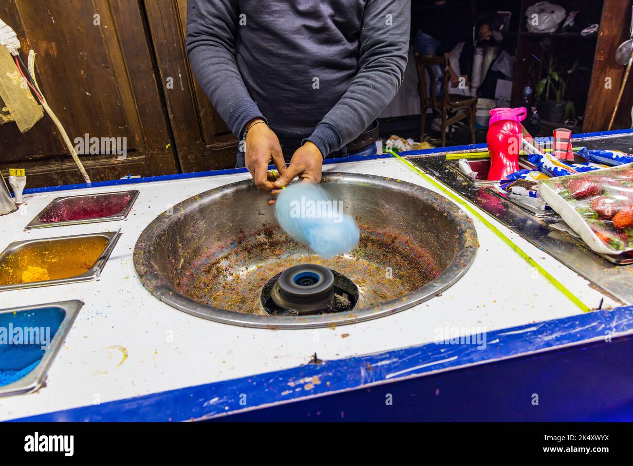 Cairo, Egypt. Man making spun sugar, cotton candy, at a shop on El Moez ...