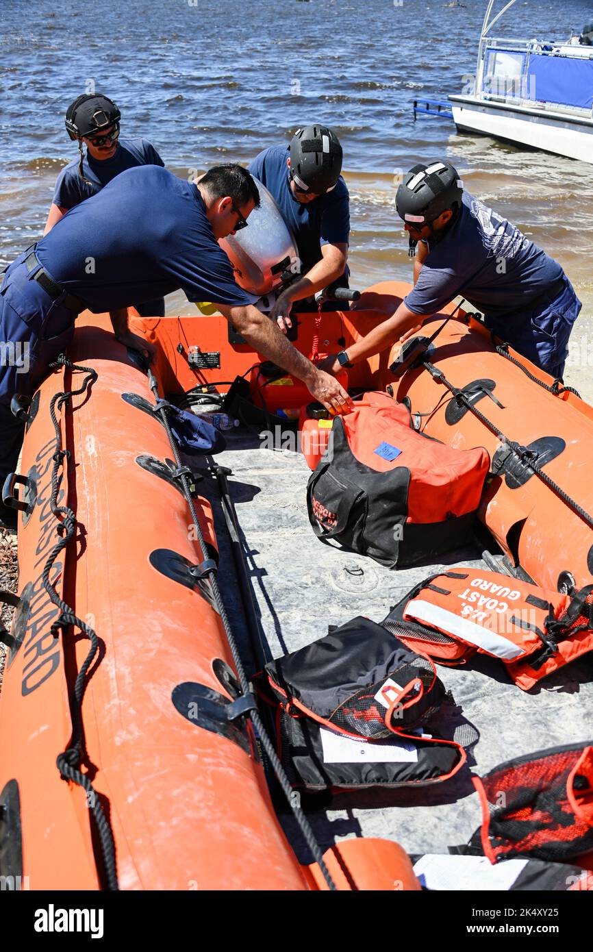 Coast Guard personnel from the Gulf, Atlantic, and Pacific Strike teams prepare to launch a shallow water boat to assist residents of Pine Island, Florida, Oct. 2, 2022. The strike forces transferred people in need to Florida’s mainland to seek shelter and resources. (U.S. Coast Guard photo by Petty Officer 3rd Class Ian Gray.) Stock Photo