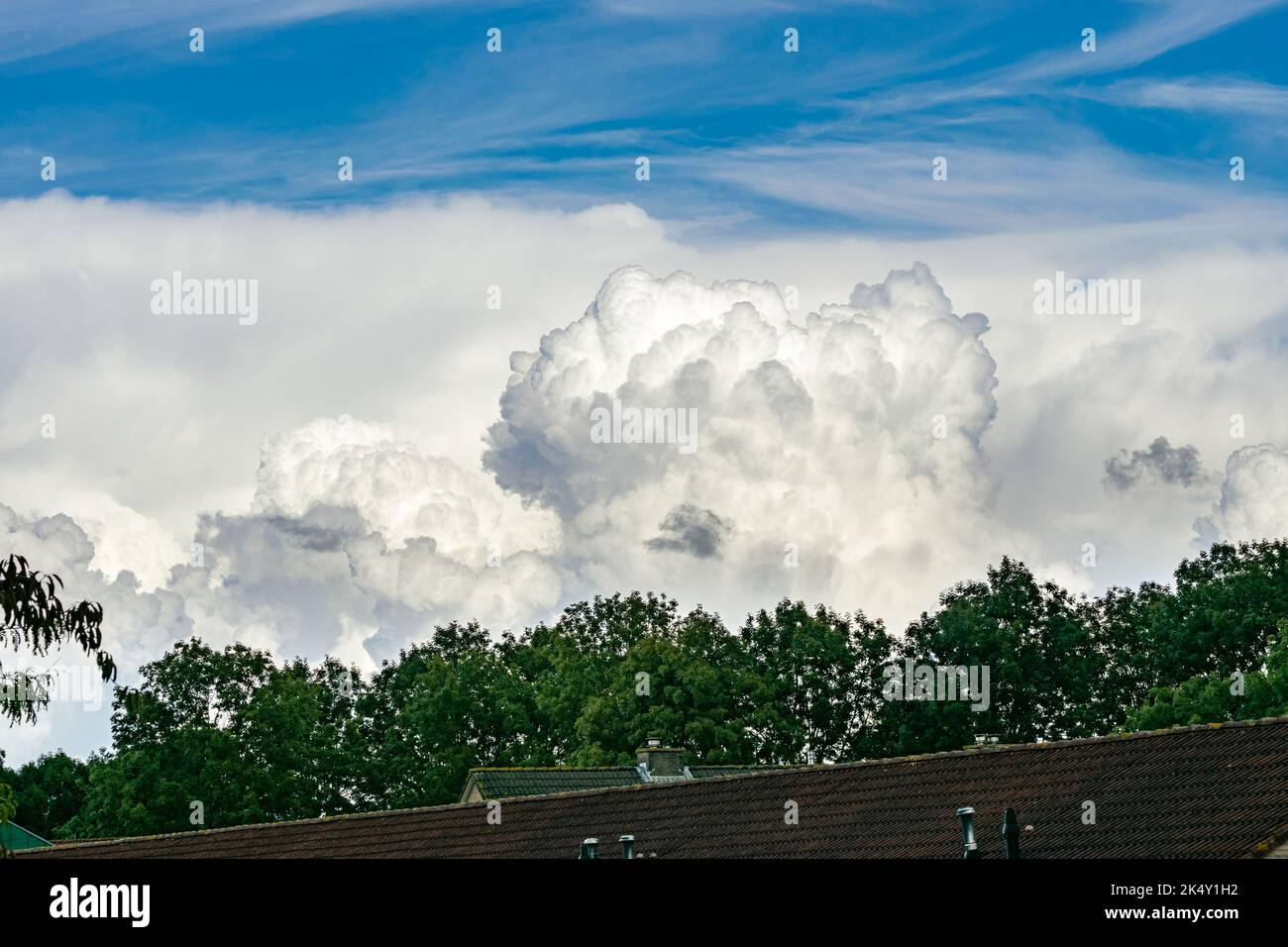 Massive towering cumulus clouds, known as cumulus congestus, are developing into storms in the distance Stock Photo