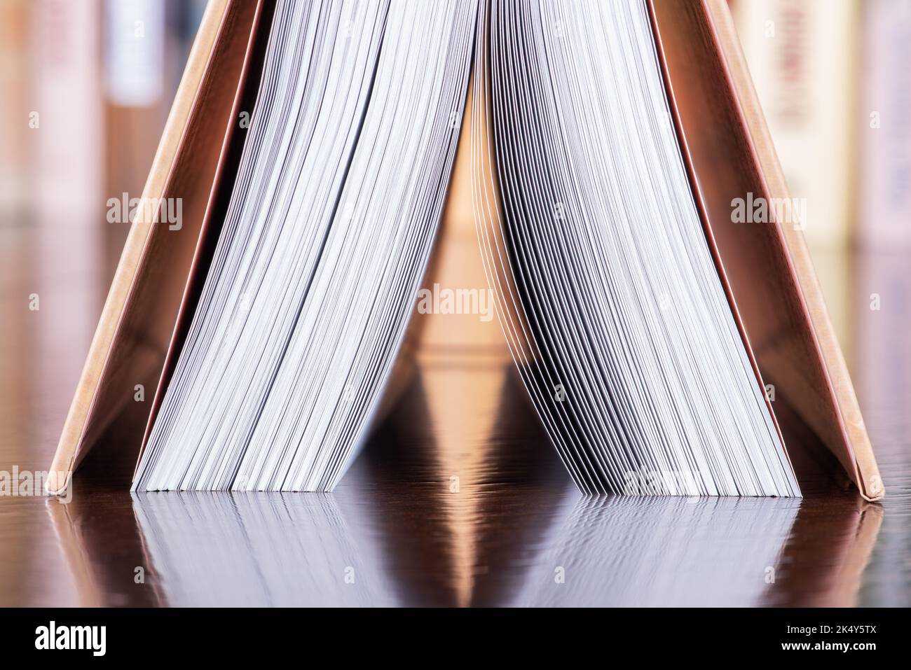 Upside down open book on desk in library Stock Photo