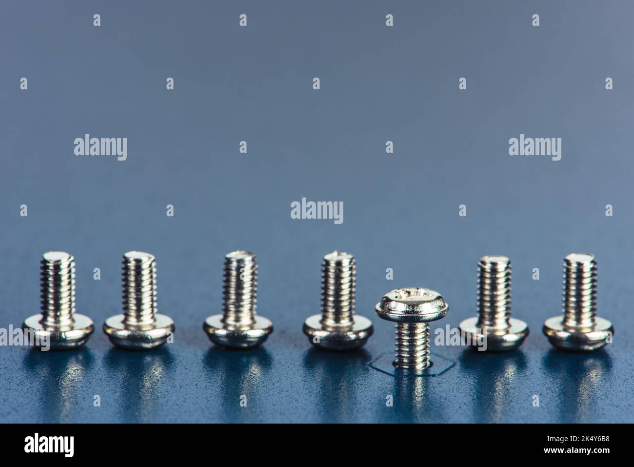 Row of Screws on Metal Surface Texture Stock Photo