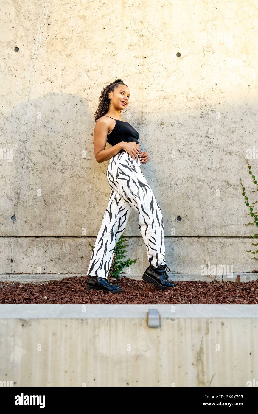 Portrait of an Edgy Young Black Woman Standing in Front of a Concrete Wall Stock Photo