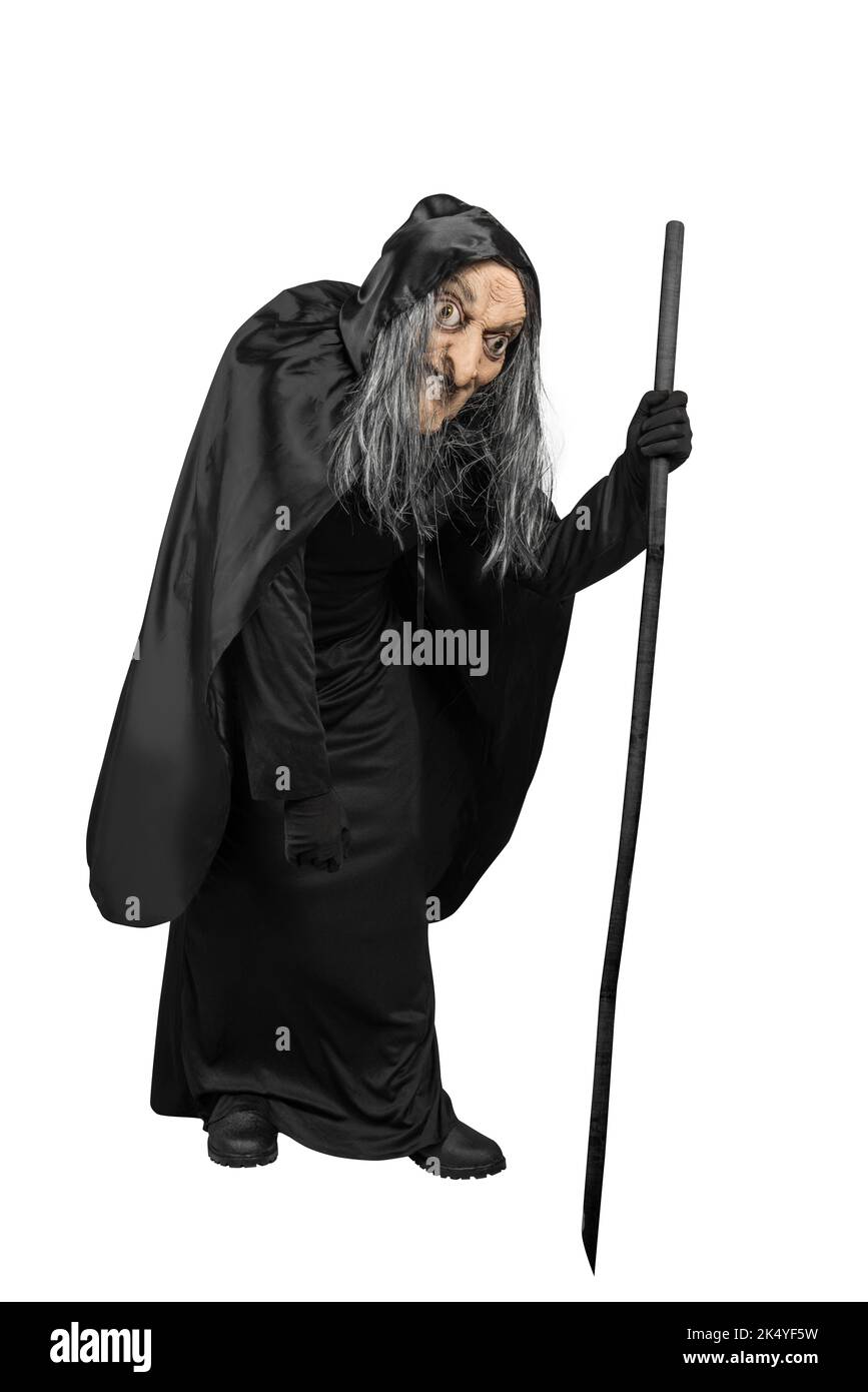 Old witch in a cloak standing with a stick isolated over white ...