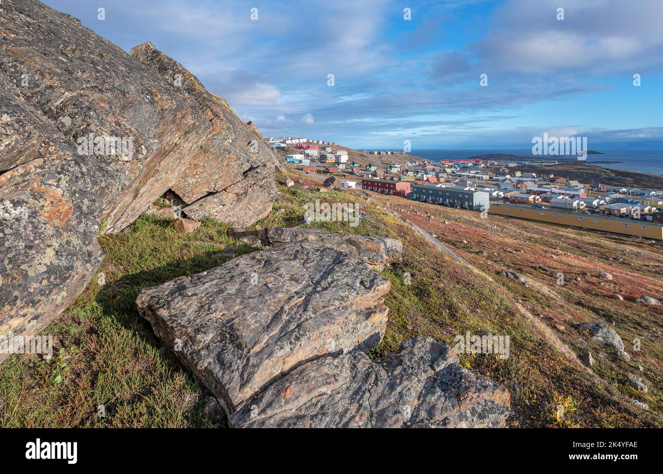 Overview of the city of Iqaluit with large boulders on the hillside above Stock Photo