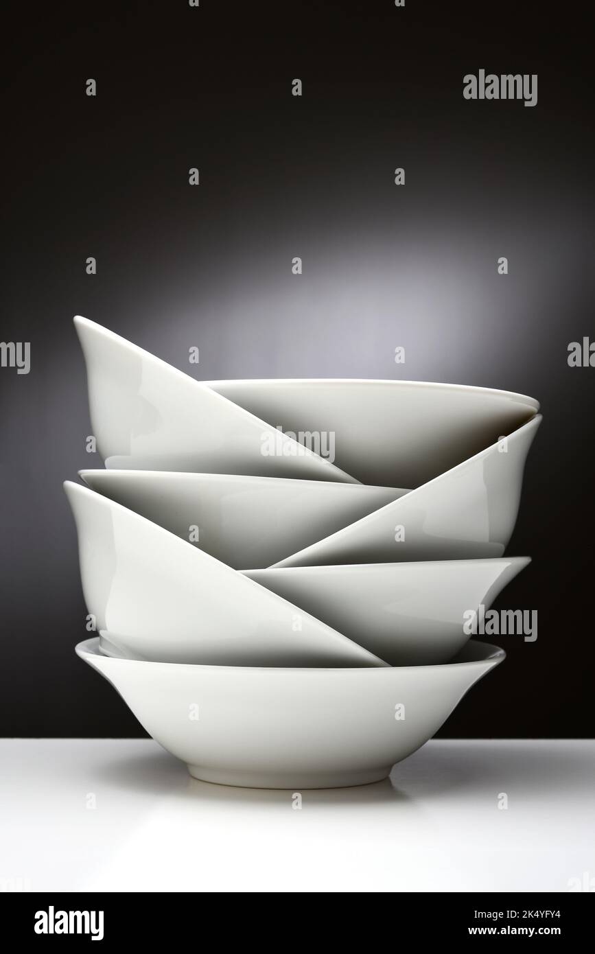 White Bowls Still Life. A group of white nested bowls on a light to dark background. Stock Photo