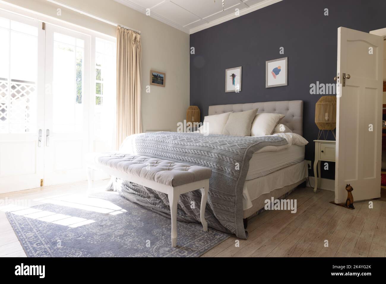 General view of bedroom interior with bed and big window. House ...