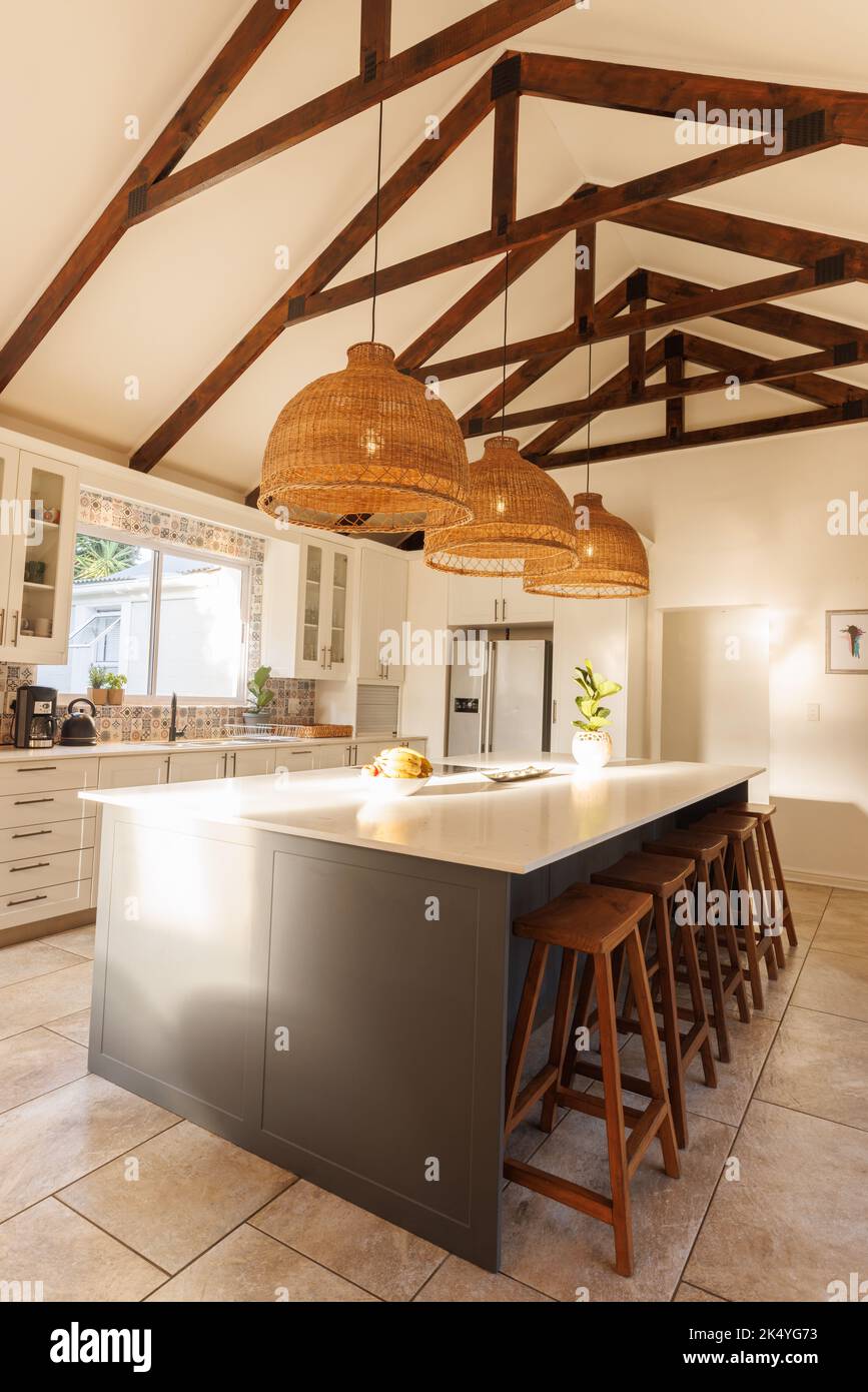 General view of modern kitchen with countertop, chairs and kitchen