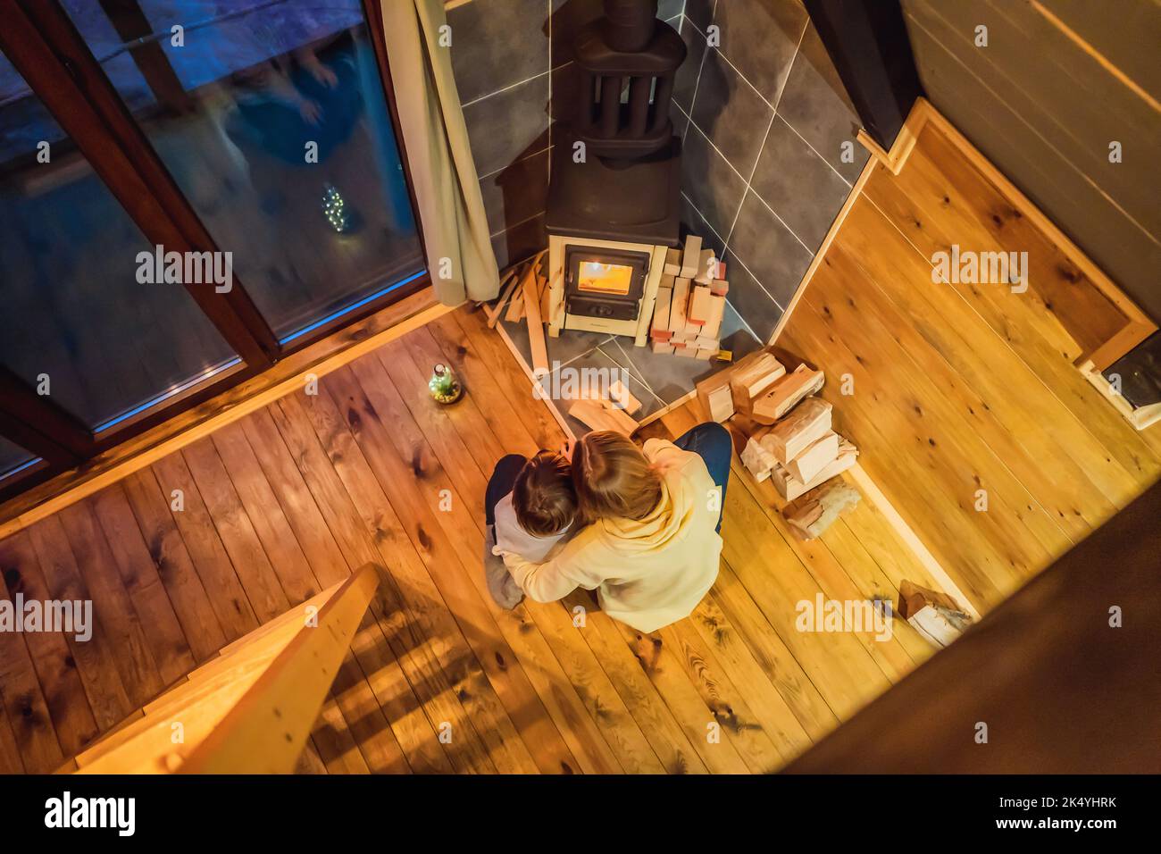 Mom and son spend time by the fireplace in Glamping. Rest in the mountains in Glamping. Cozy fireplace in a mountain house Stock Photo
