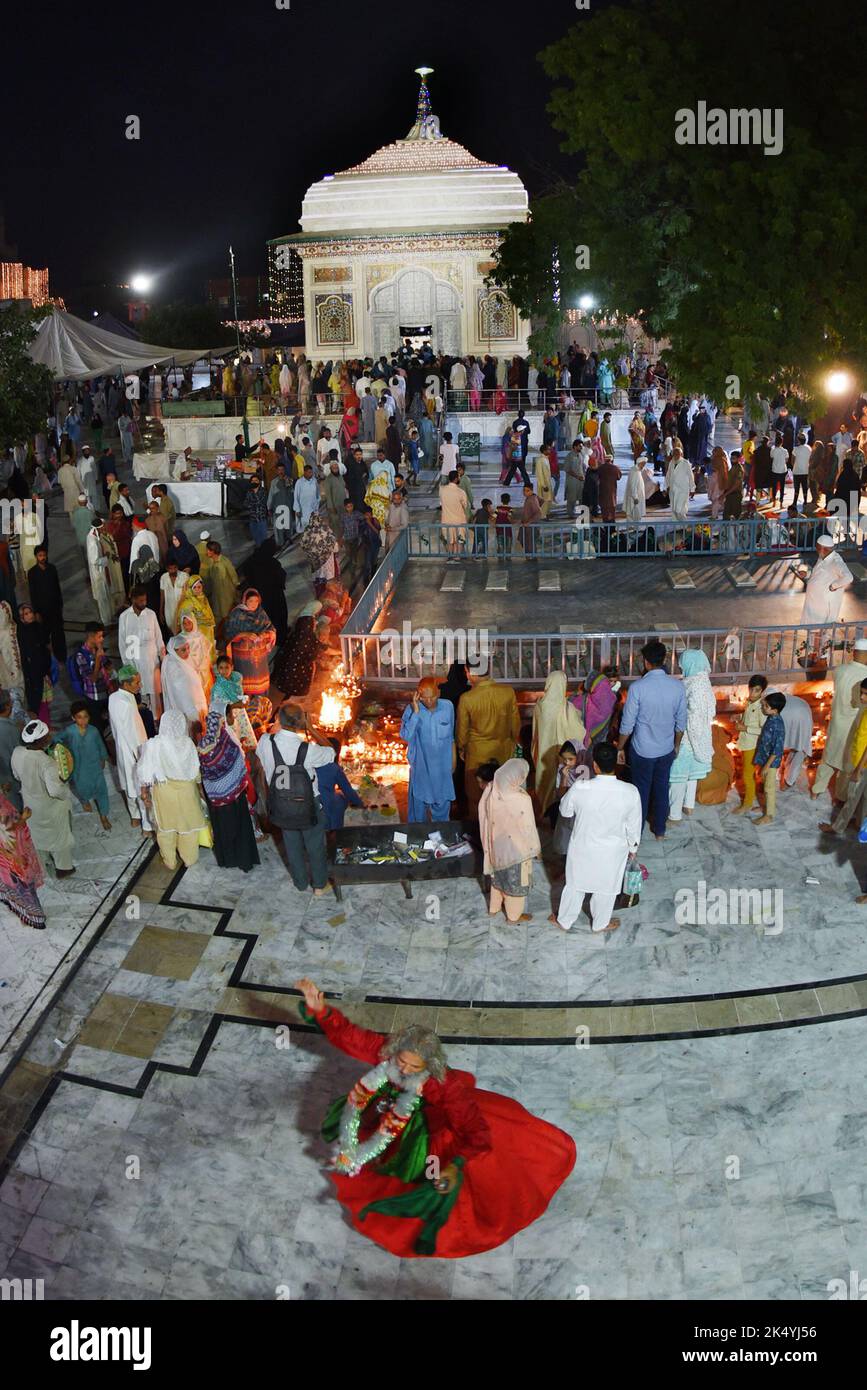 Lahore, Punjab, Pakistan. 4th Oct, 2022. Pakistani Muslim devotees light candles earthen oil lamps and devotees (Malang) dance at the shrine of famous fifteenth century Sufi Saint Hazrat Mir Mohammed Muayyinul during 399th URS birth anniversary celebrations in Lahore. Thousands of people across the country visit the shrine to pay tribute to him during a three-day festival. The saint was equally popular among the Muslim and Sikh religions, as Mian Mir went to Amritsar (India) in December 1588 to lay the foundation stone of Sikh's holiest site, the Golden Temple, which is commonly known as Sri Stock Photo
