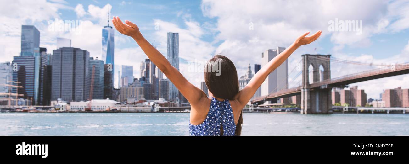 Success in business career in New York City. Panoramic banner. Aspirational Happy free woman cheering by NYC New York city skyline with arms up. Goal Stock Photo
