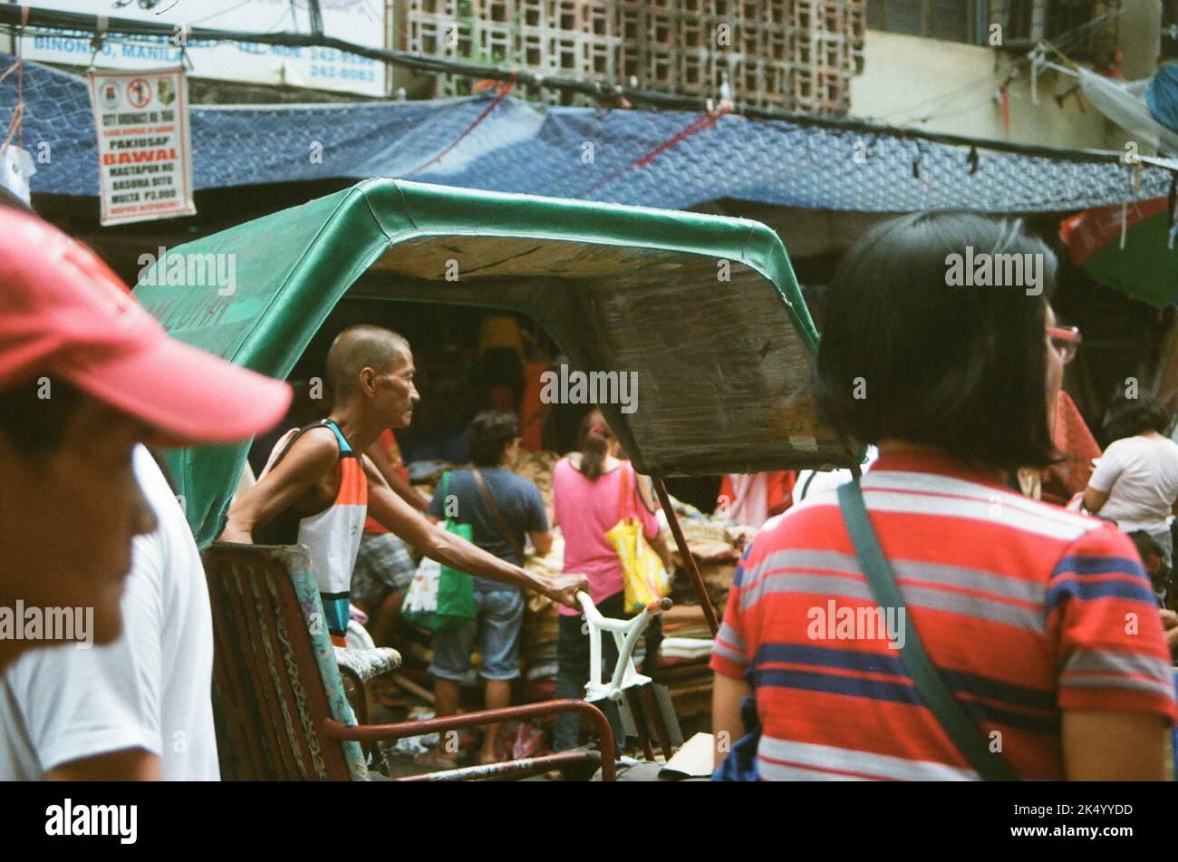 A pedicab driver in the middle of the hustle and bustle in Manila Stock Photo