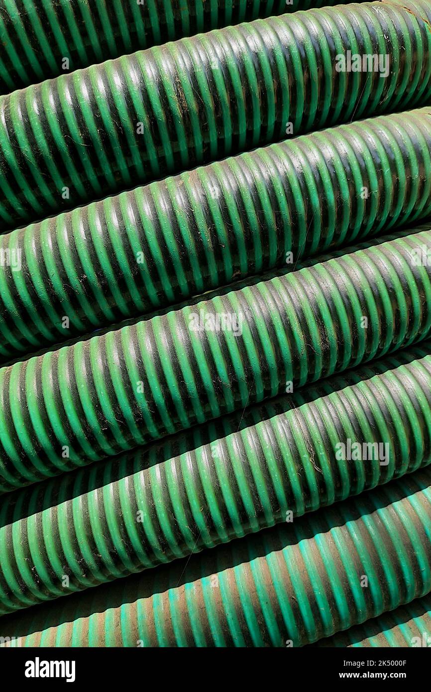 Closer view of green, piled roll of reinforced PVC pipe Stock Photo Alamy