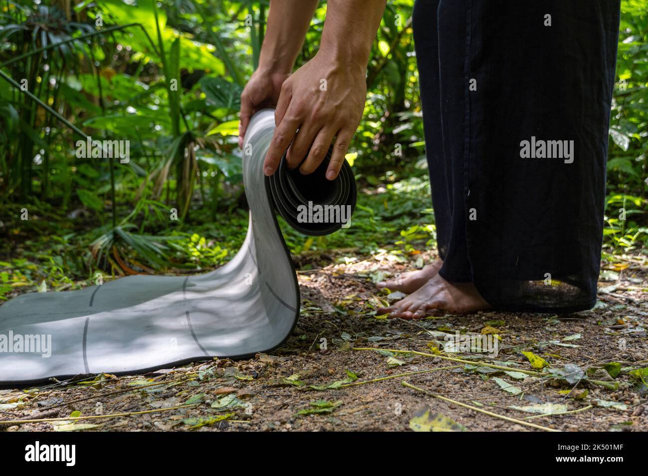 Young latin man arranging his yoga mat, inside a forest on a plain, direct contact with nature, mexico Stock Photo