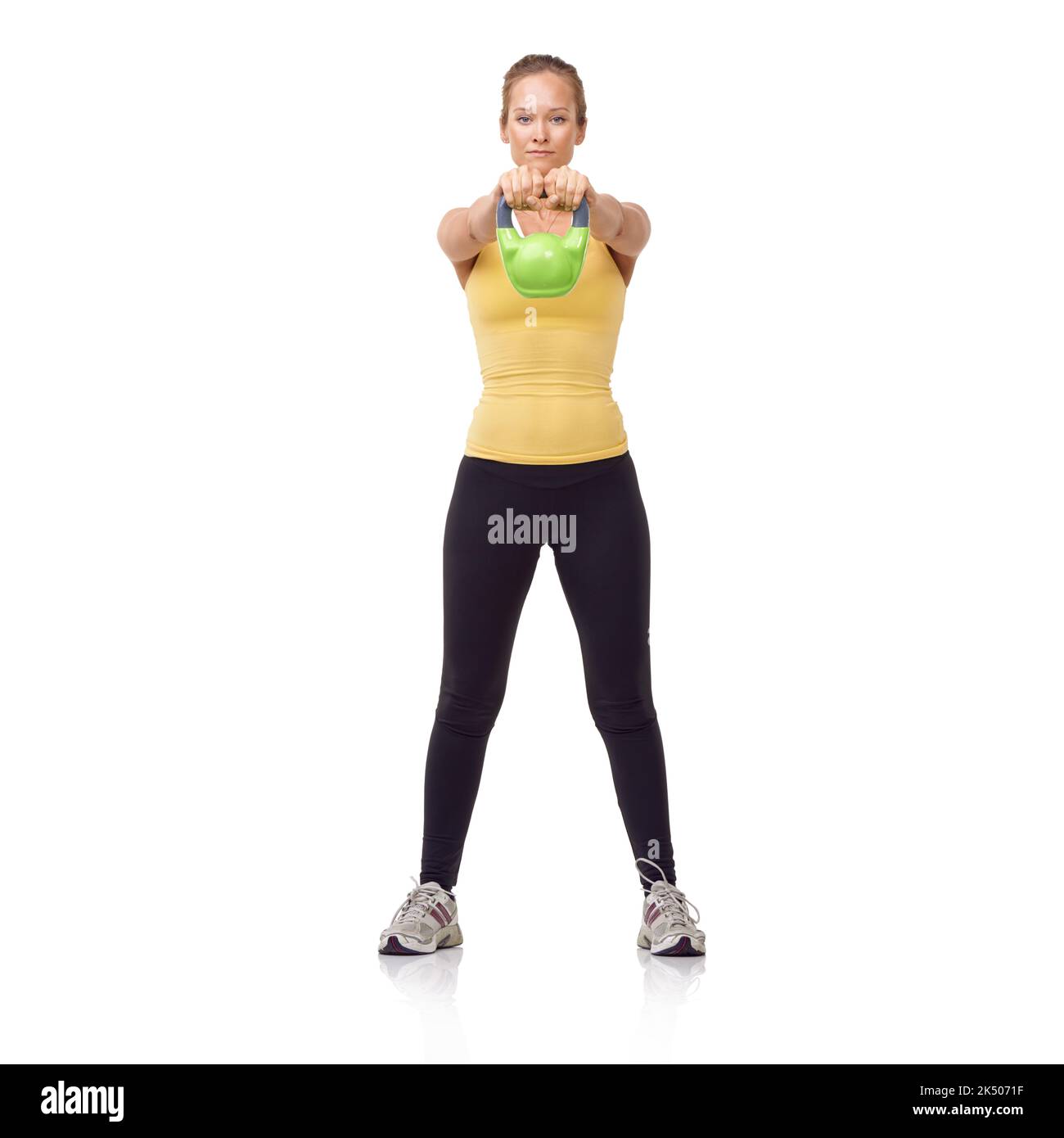 It takes strength to do this. A beautiful blonde woman performing a two-handed kettlebell swing. Stock Photo