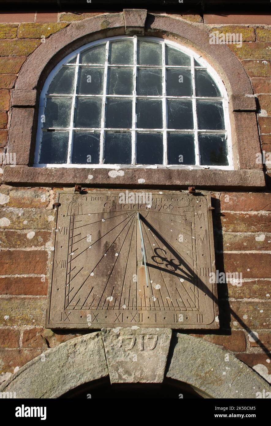 Close up of window and sundial over entrance door to St John's Old Church in Pilling, Lancashire, with keystone dated 1717 above the door. Stock Photo