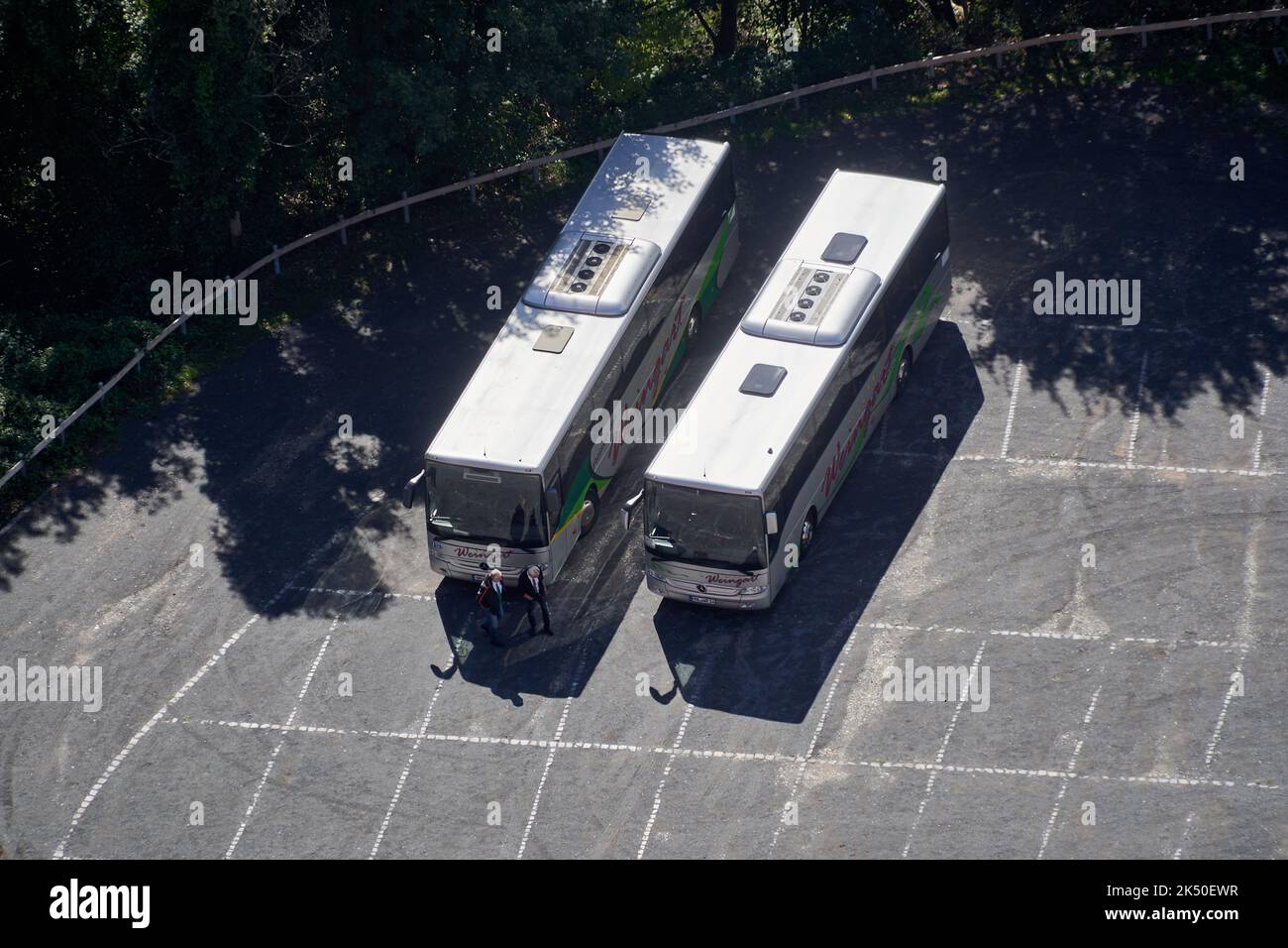 Bad Frankenhausen, Germany, September 21, 2022: Aerial view of tour buses parked in empty parking lot with white marker stripes Stock Photo