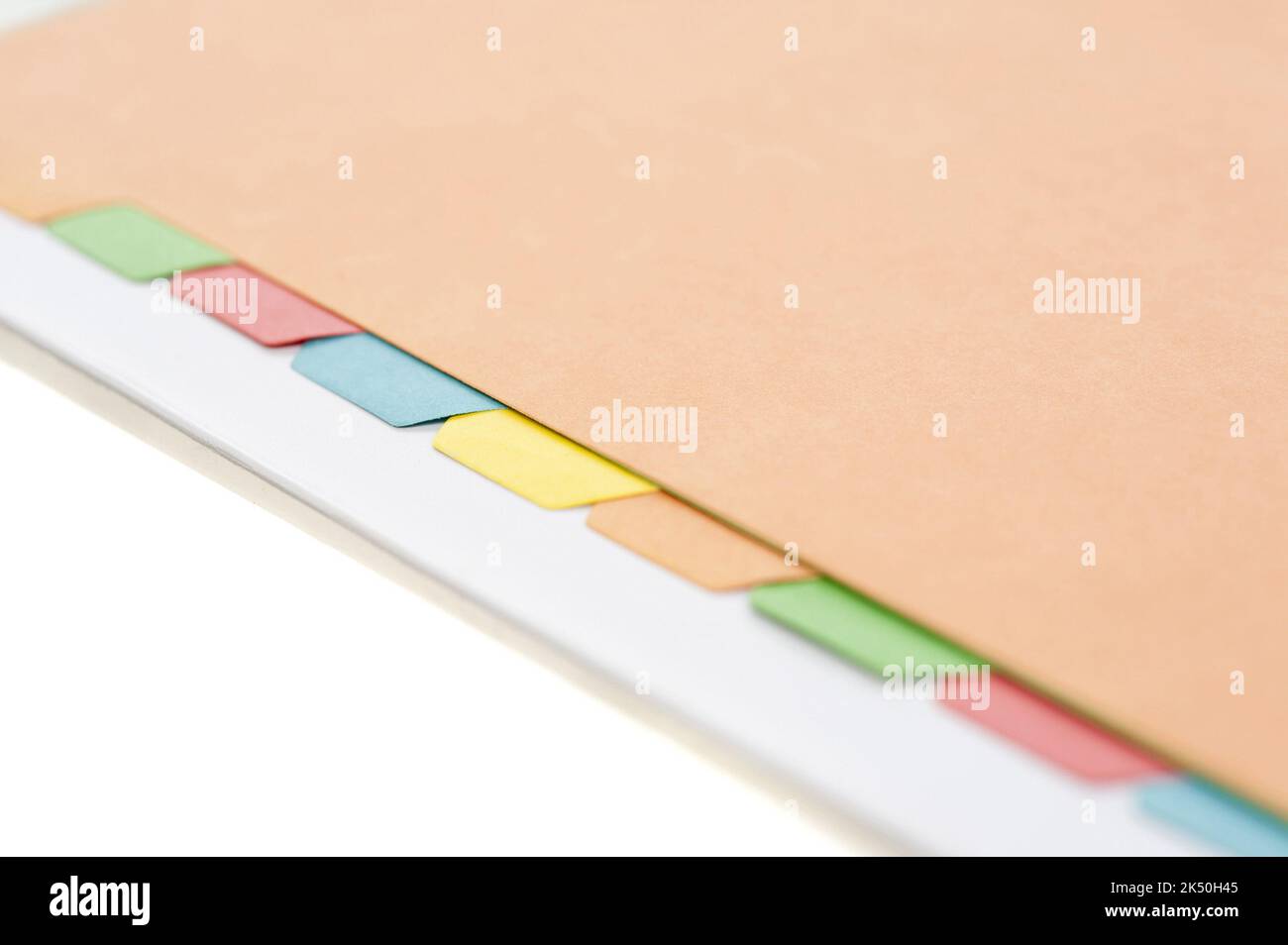 Close view of some colored index tabs lined up in a manila folder against a white background Stock Photo