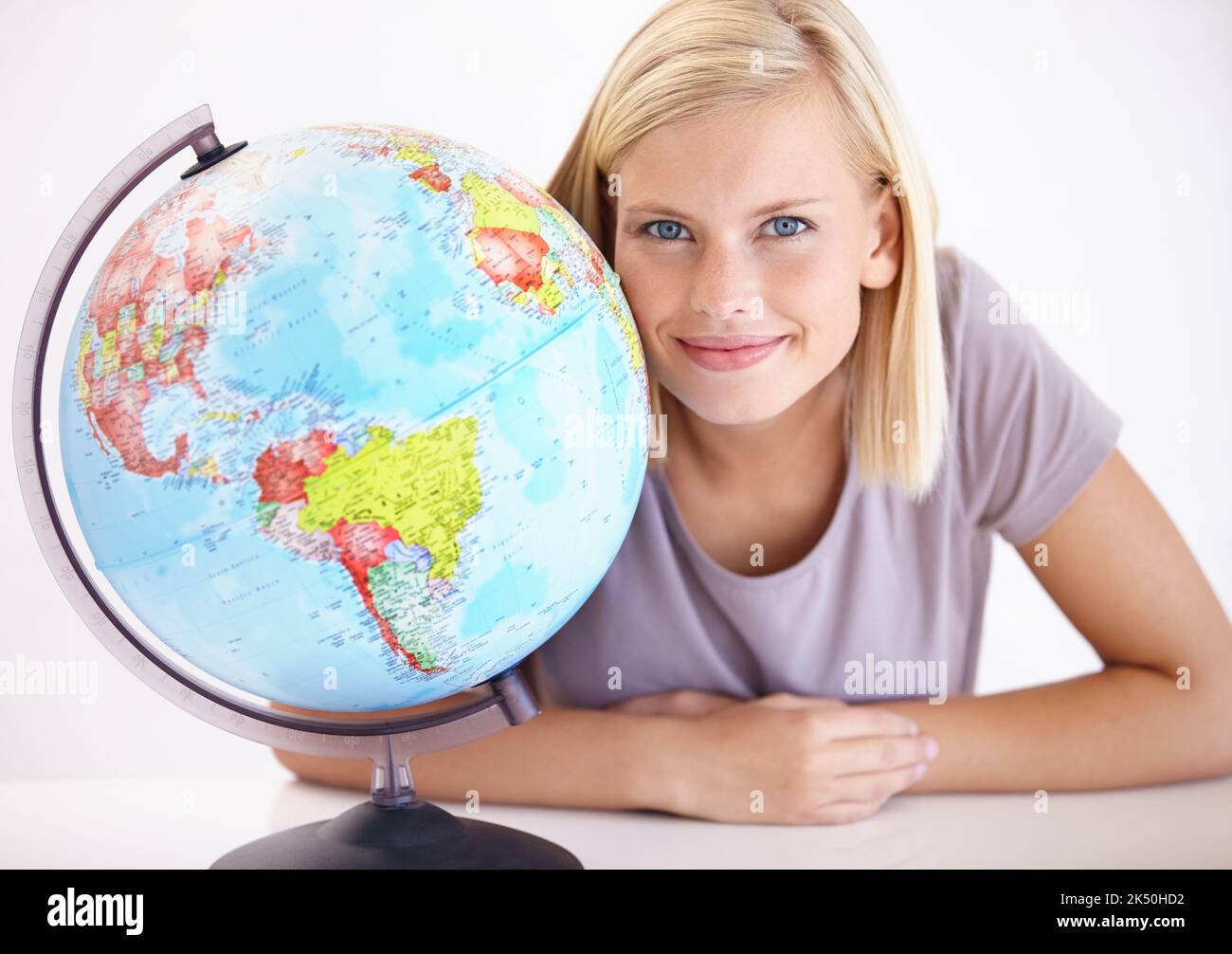 Geography is her speciality. A pretty young geography teacher smiling