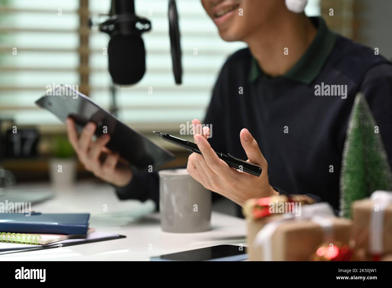 Image of radio host using microphone and laptop to recording podcast in