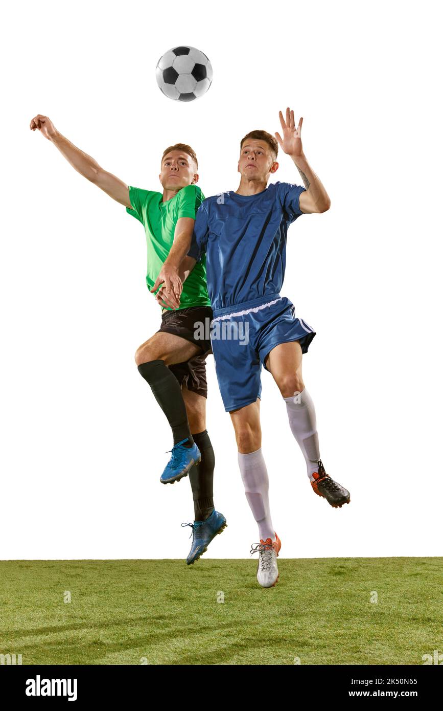 Two soccer players in action, motion on green grass flooring isolated over white background. Concept of global sport, championship, competition Stock Photo