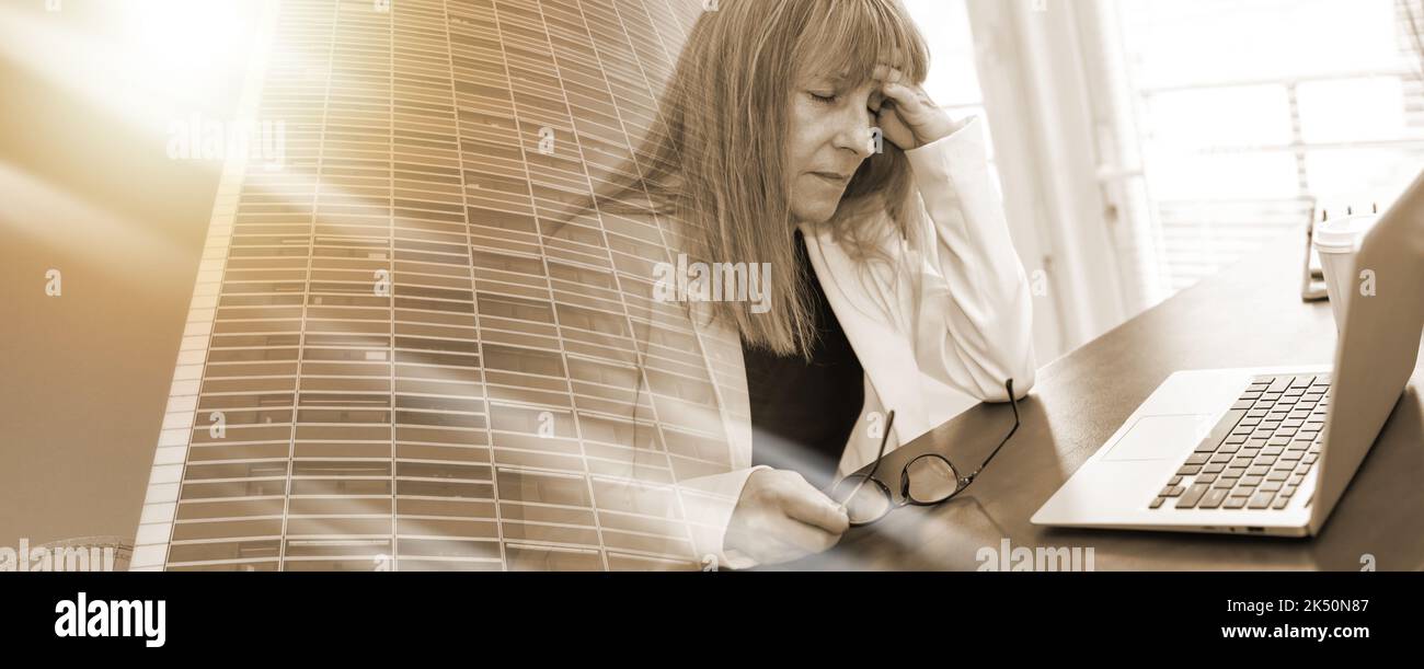 Stressed businesswoman sitting in office with hand on forehead ...
