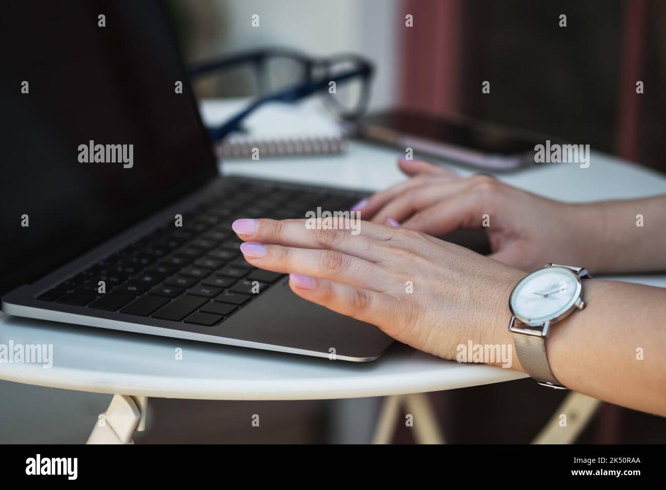 Close up image of woman hands typing on laptop computer keyboard and surfing the internet on office table, online, working, business and technology, internet network communication concept.  Stock Photo