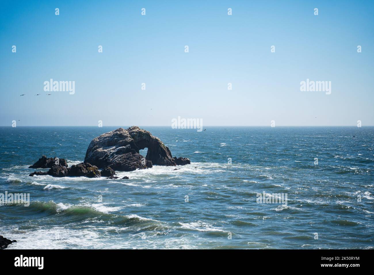 Heart shaped black rock in Pacific ocean on a bright sunny day. Travelling in the usa NoCal California Nature travel landscape background Stock Photo
