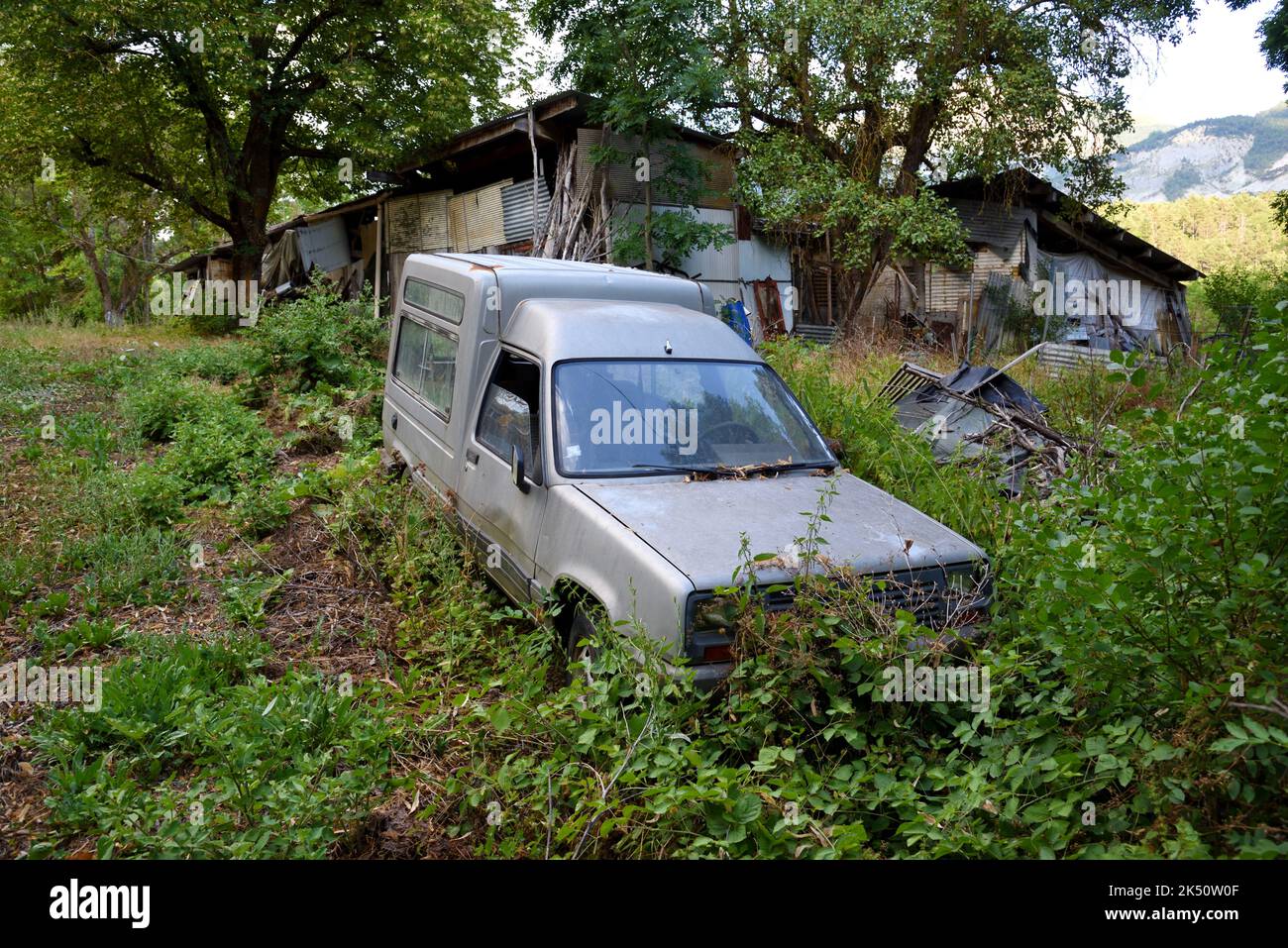 Rusty Old Car Wreck or Derelict Car Renault Express Van in Abandoned Farm Yard Stock Photo