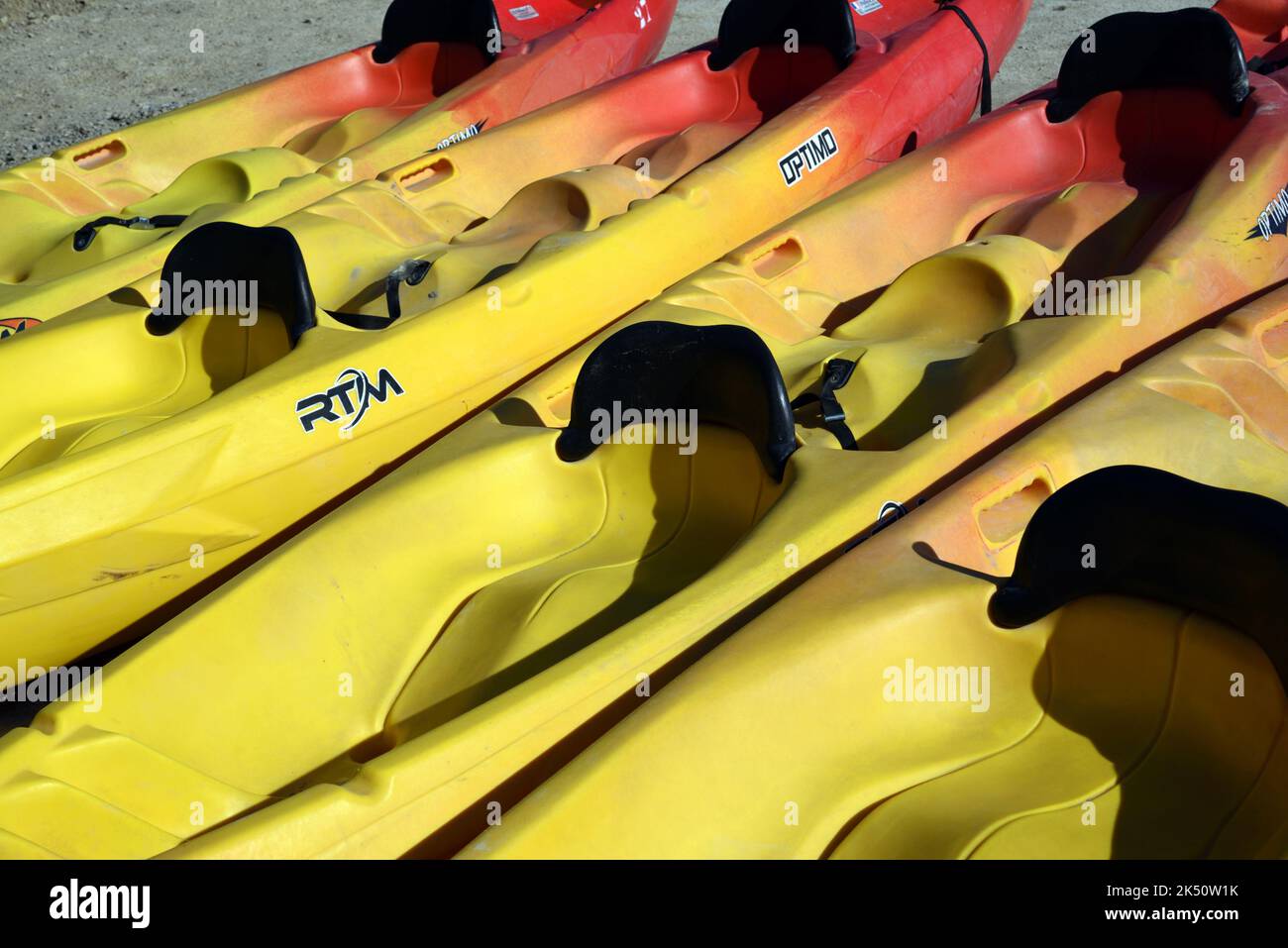 Row or Line of Plastic Yellow Canoes or Kayaks Stock Photo