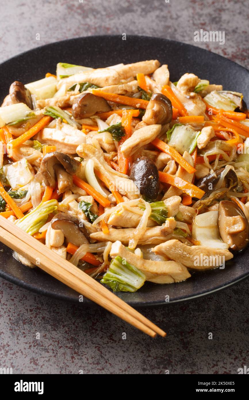 Chop Suey Chicken Stir Fry with vegetables close-up in a plate on the table. Vertical Stock Photo
