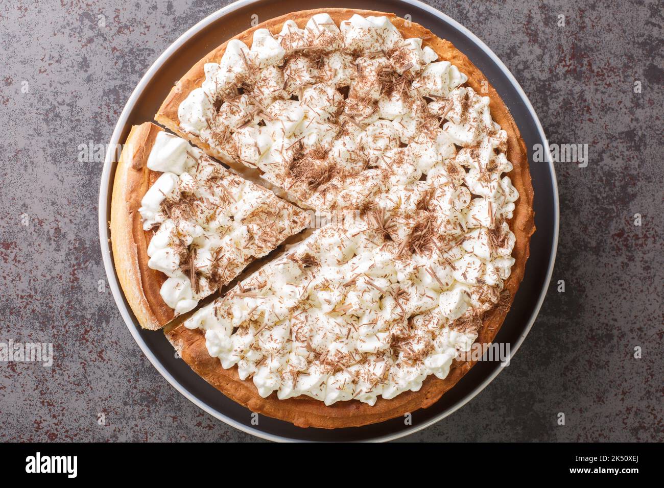 Dutch and Belgian Rice cake tart with whipped cream and chocolate chips close-up in a plate on the table. Horizontal top view from above Stock Photo