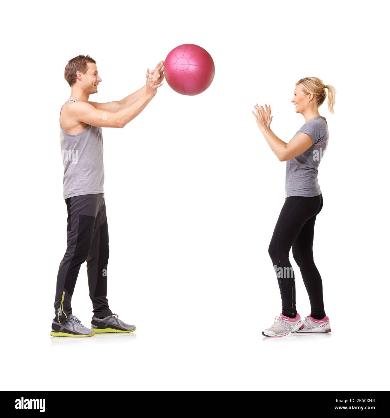 Getting fit is fun. A man and woman exercising by throwing a medicine
