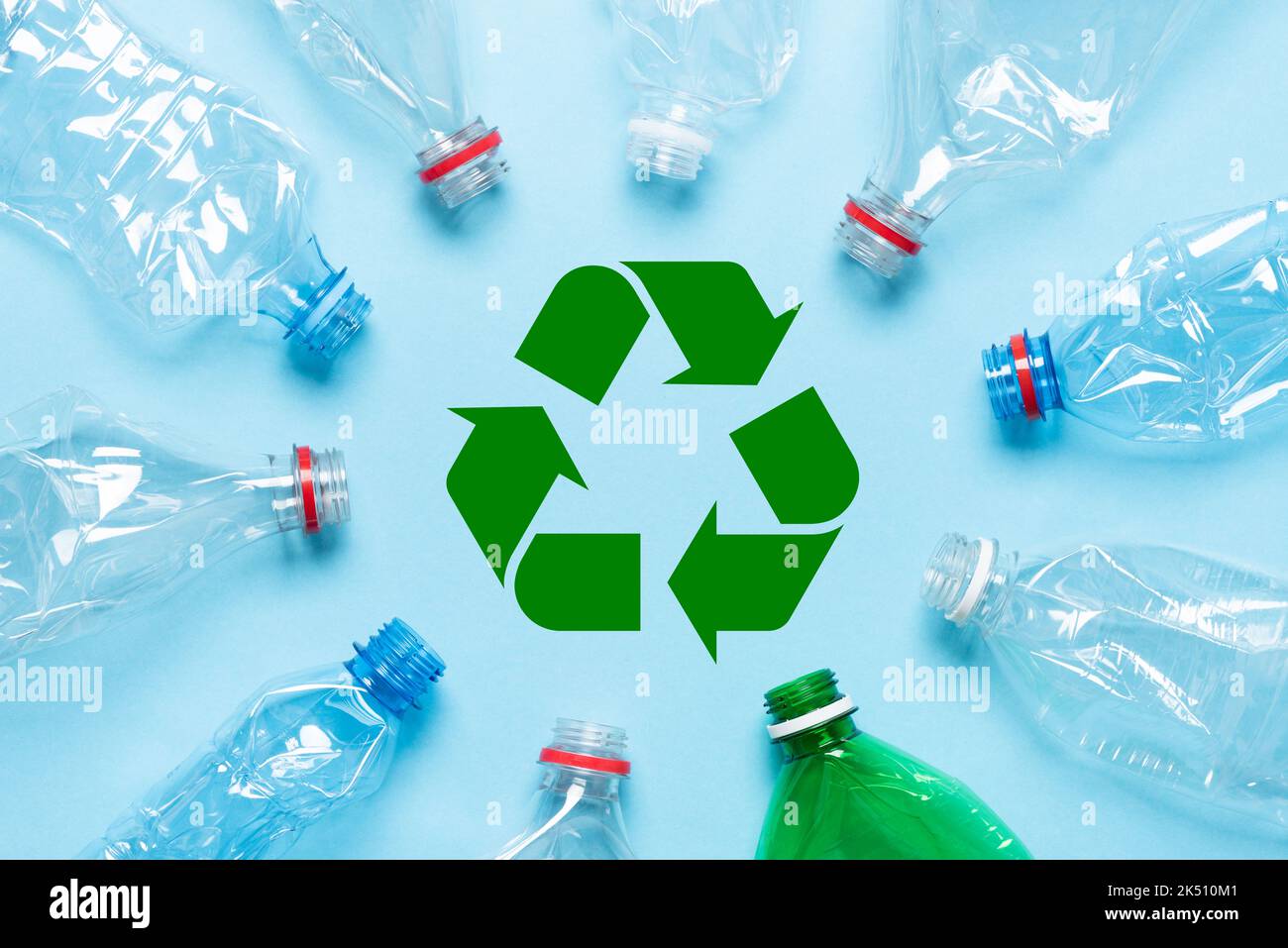 Empty crumpled plastic bottles on blue background with recycle symbol ...