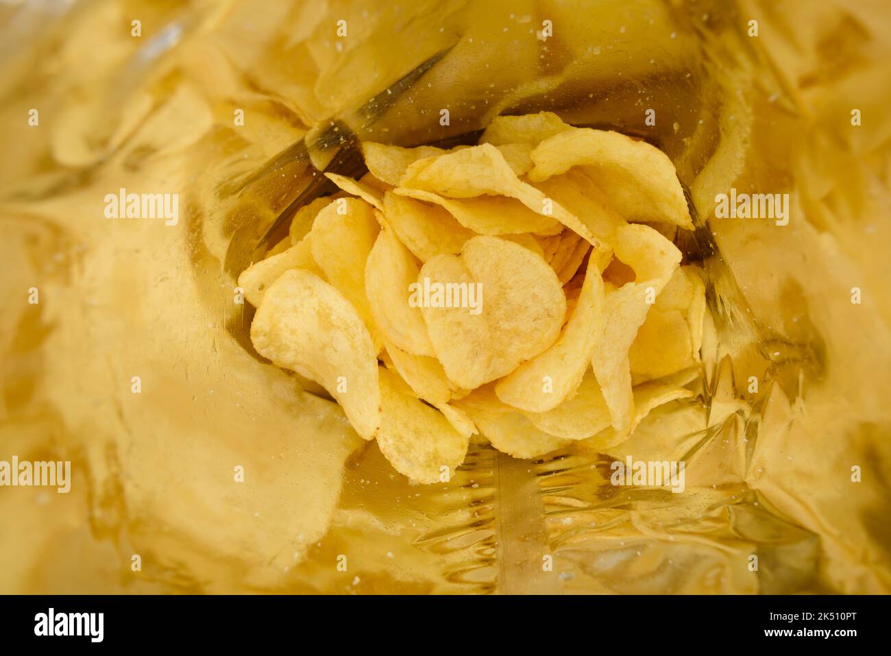 Crispy potato chips with salt inside foil bag package Stock Photo