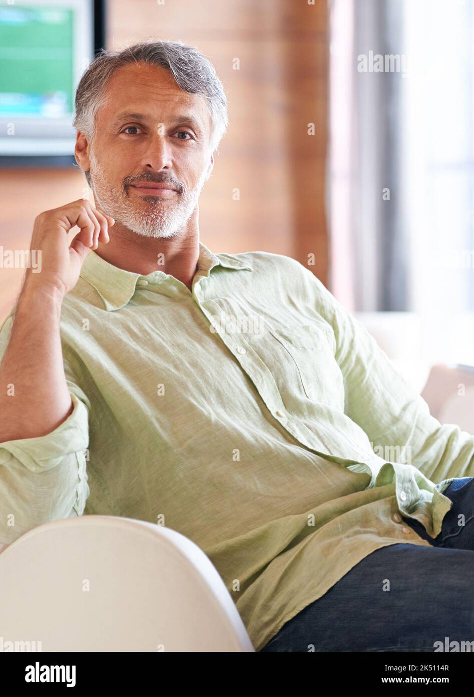 We all need a break. a man sitting confidently on a chair indoors Stock Photo Alamy