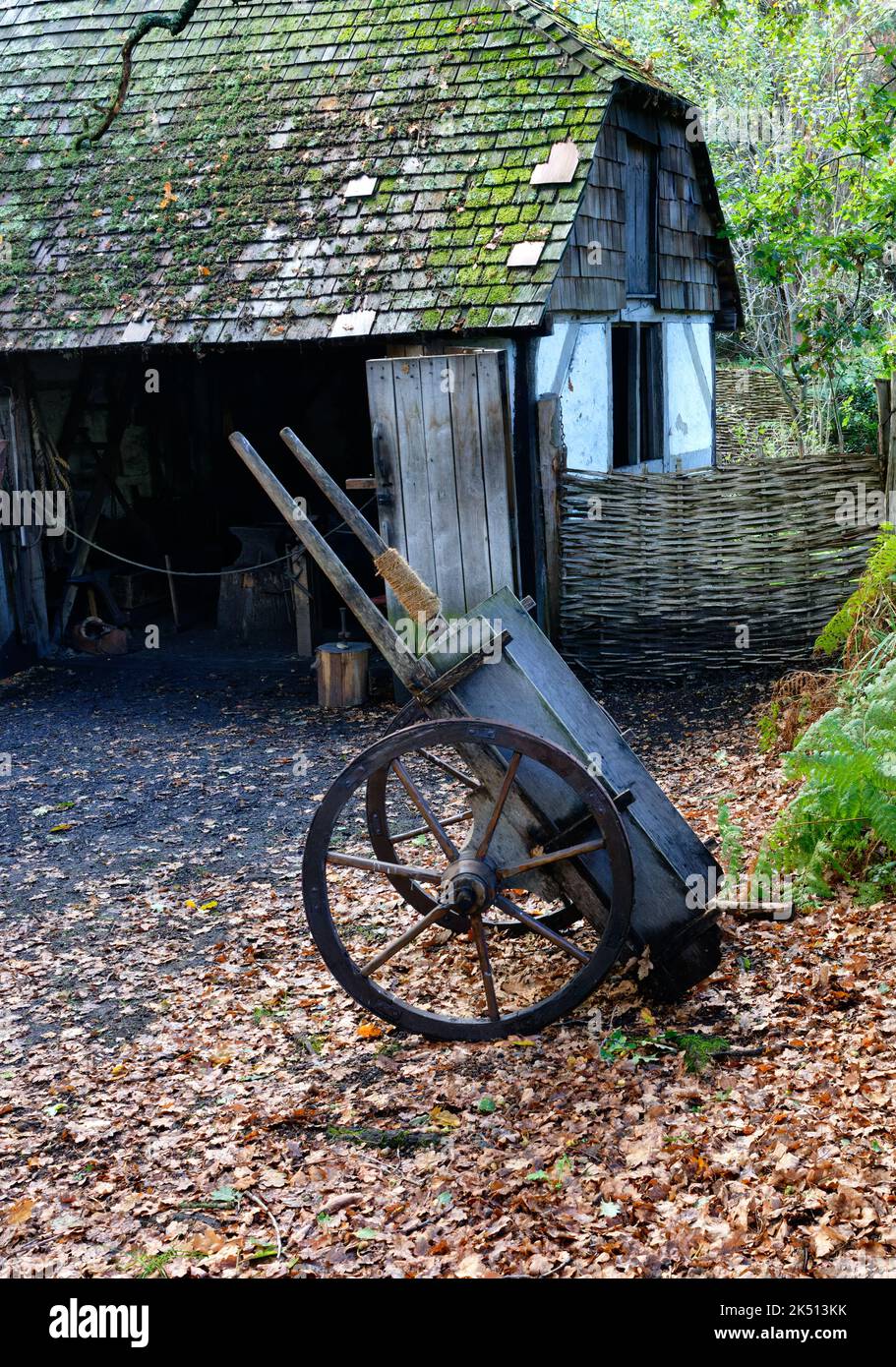Cart sitting outside a building in the medieval recreation of Little Woodham in Hampshire Stock Photo