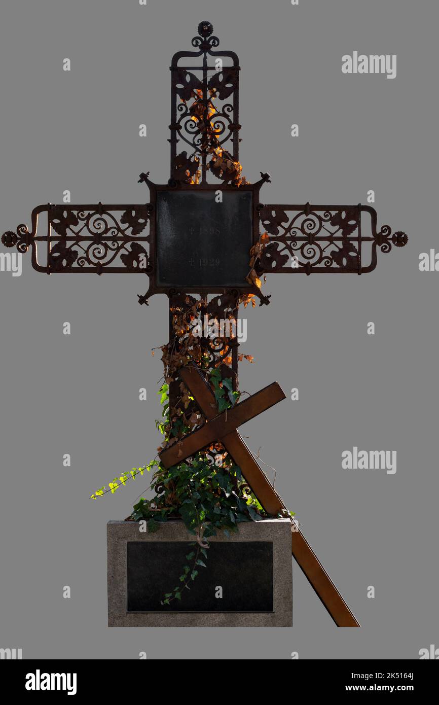 Cut out of wrought iron ornate cross, old and rustic, ivy growing around it, with wooden simple cross Stock Photo