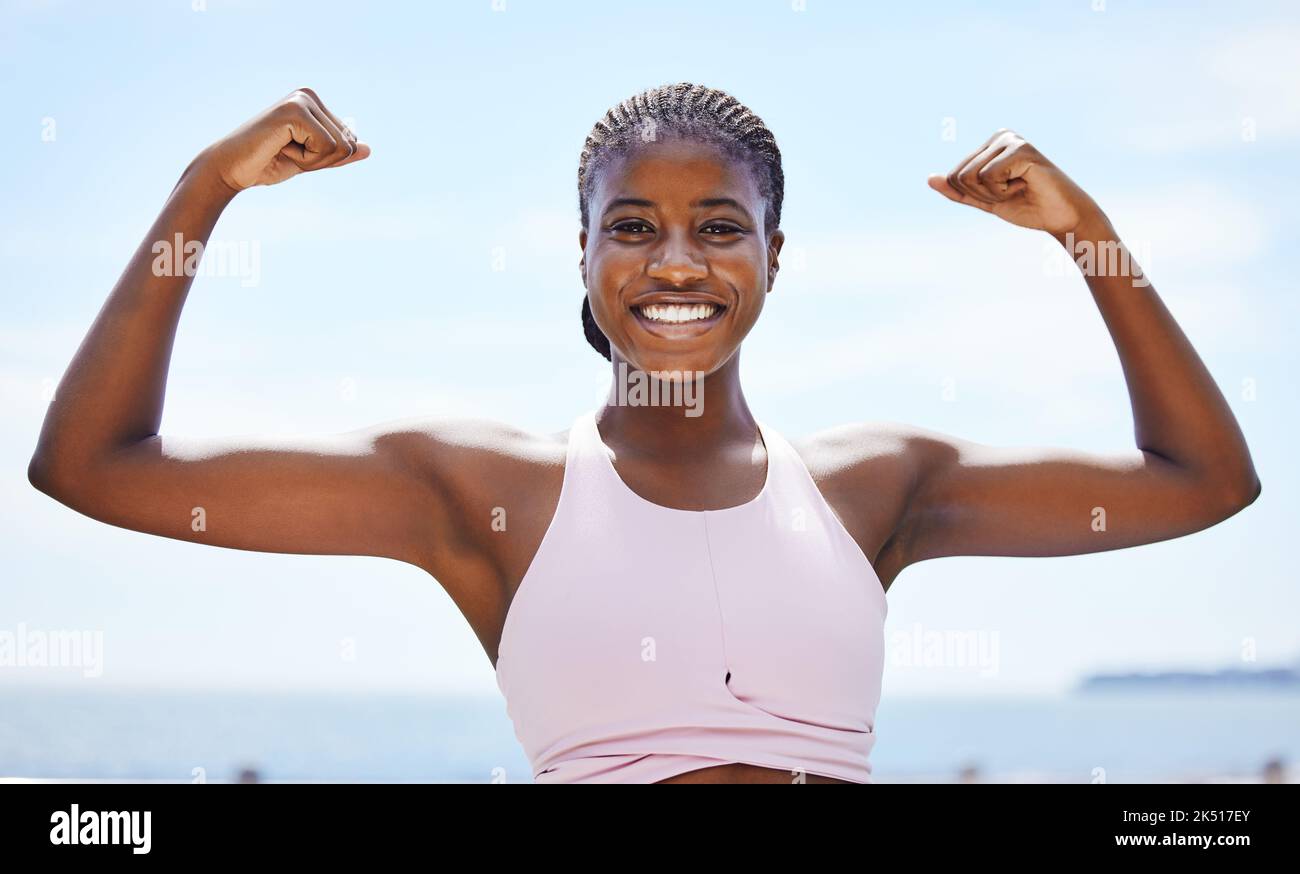 Strong black woman flexing arms, muscle and body power, fitness and wellness in urban Jamaica