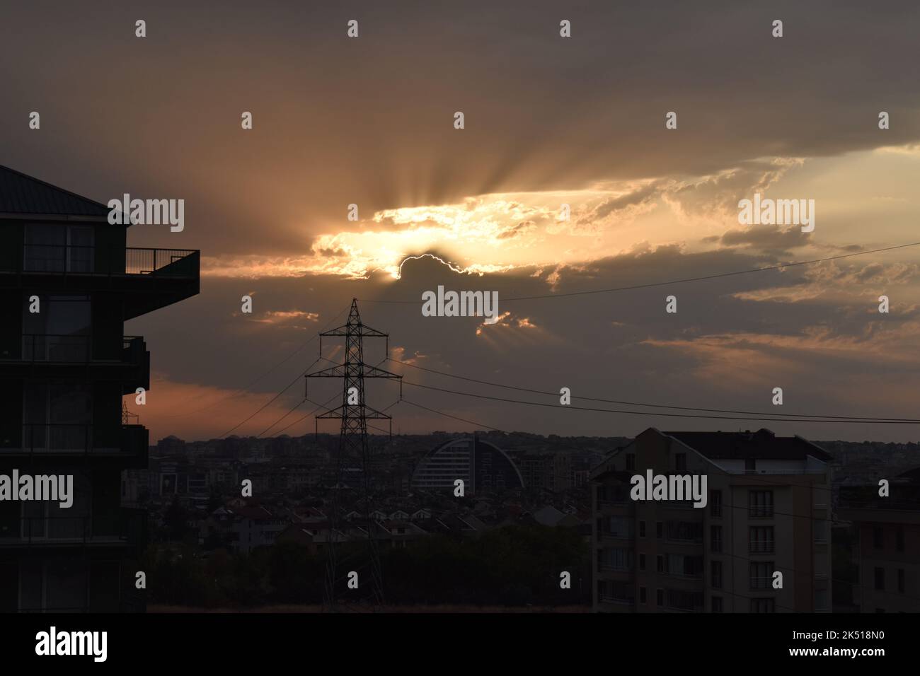 High voltage lines and cityscape at sunset Stock Photo