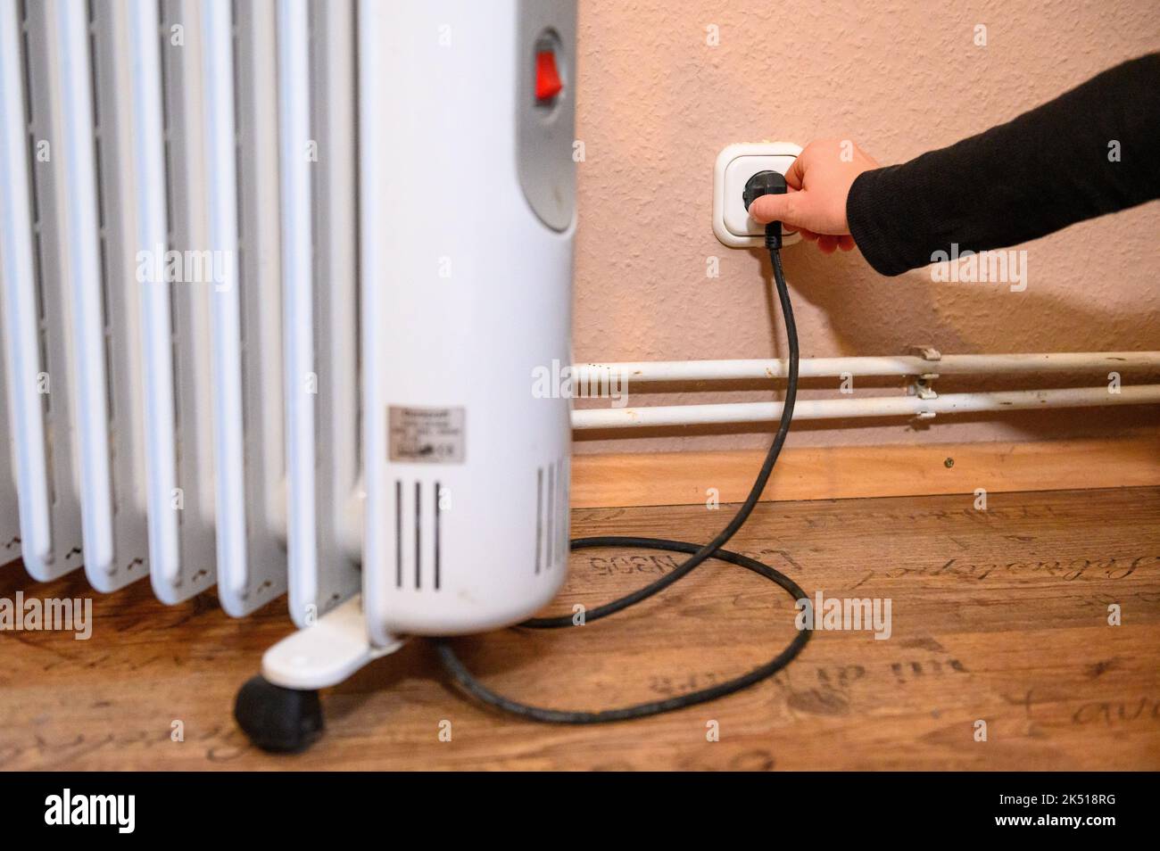 Hamburg, Germany. 24th Sep, 2022. A woman pulls the plug of an electric heater out of the socket. Credit: Jonas Walzberg/dpa/Alamy Live News Stock Photo