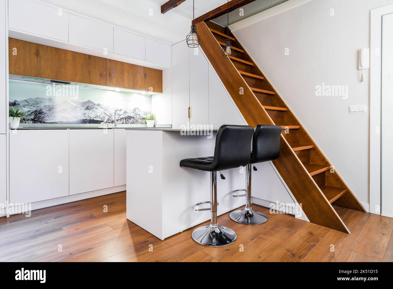 White cabinets placed in kitchen in modern apartment with wooden ...