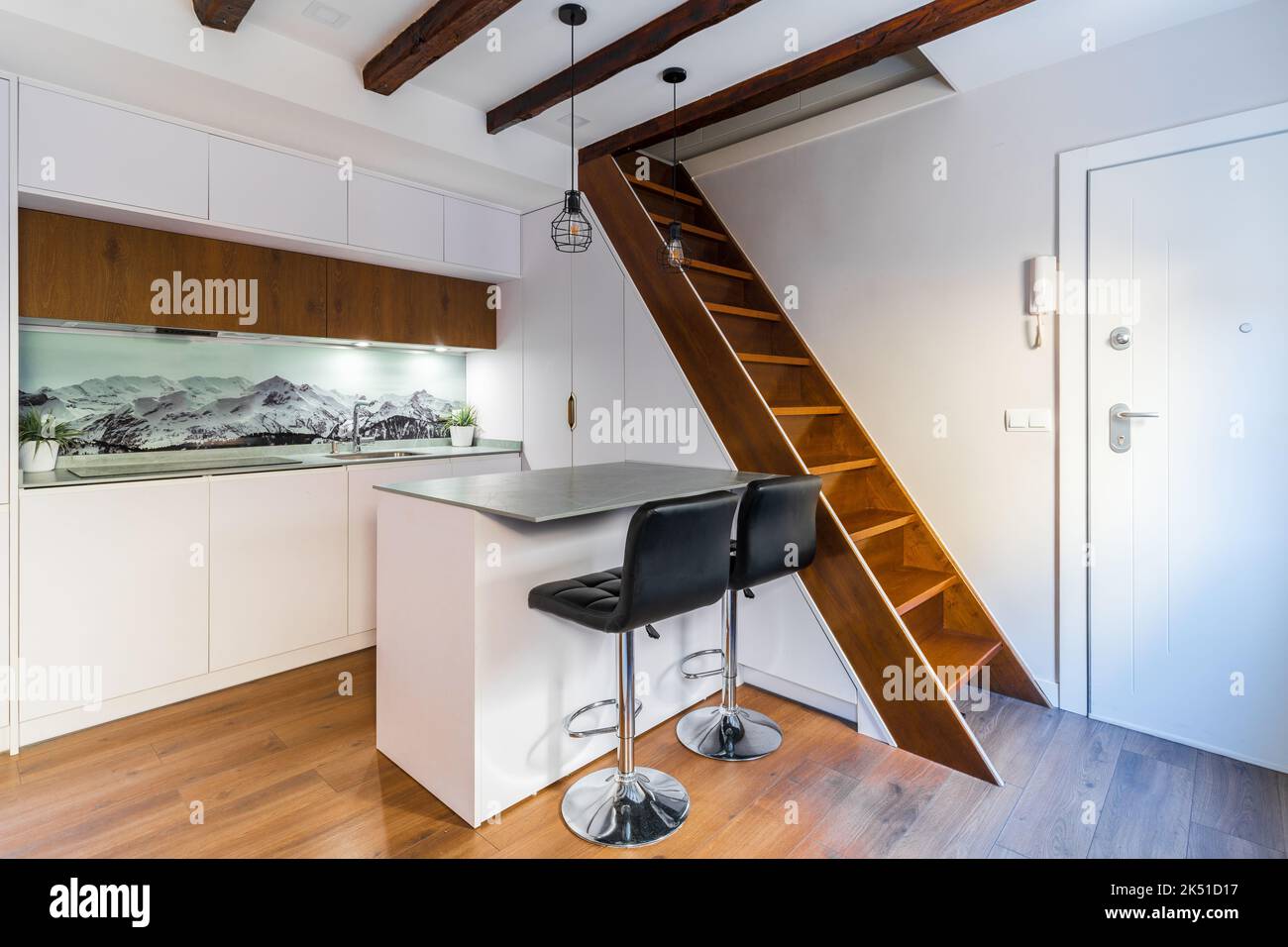 White cabinets placed in kitchen in modern apartment with wooden ...