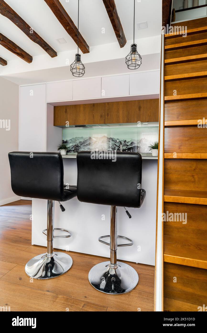 White cabinets placed in kitchen in modern apartment with wooden ...