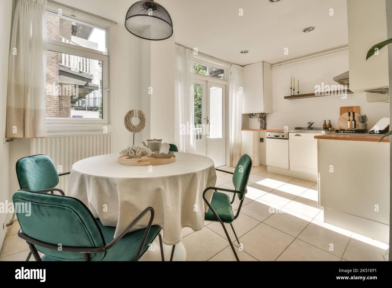 Interior of kitchen with chairs placed around dining table decorated ...