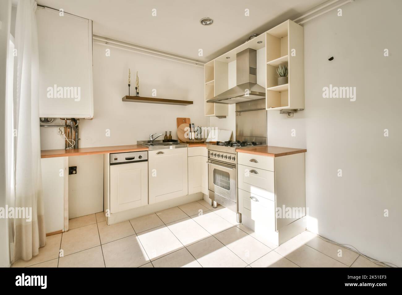 Interior of light kitchen with white cupboards and built in stove and ...