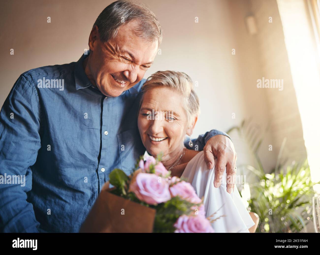 Couple, romance and flowers with a senior man and woman in celebration of valentines day or their anniversary. Retirement, love and affection with an Stock Photo