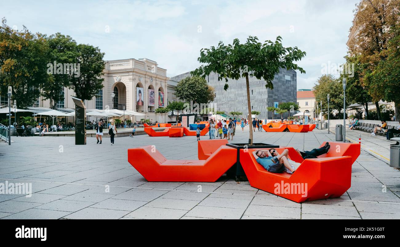 Vienna, Austria - August 28, 2022: People in the Museumsplatz square, in Vienna, Austria, in the famous MuseumQuartier district, with different museum Stock Photo