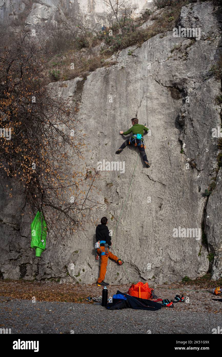 Young man with rope climbs on the rock in the Napoleonica, Trieste Stock Photo